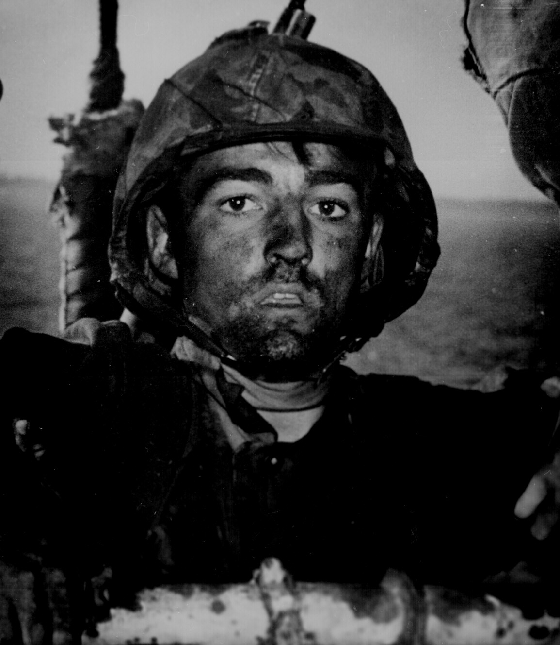 Back to a Coast Guard assault transport comes this Marine after two days and nights of Hell on the beach of Eniwetok in the Marshall Islands. His face is grimey with coral dust but the light of battle stays in his eyes.​